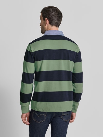 Männermodel trägt Regular Fit Sweatshirt aus reiner Baumwolle von GANT, grün-marineblau gestreift, glatte Textur, Ganzkörperansicht Rückansicht.