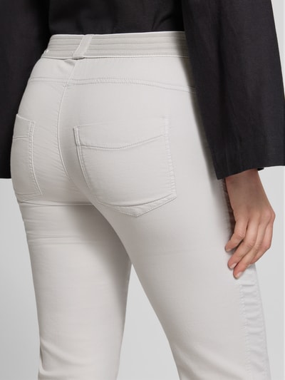 Männermodel trägt Jogpants mit elastischem Bund Modell 'Sue' von TONI, mieszanka bawełny z dodatkiem streczu, krój 3/4 fit, wpuszczane kieszenie boczne, kieszenie z tyłu, szerokość w rozmiarze 36: 37 cm, długość wewnętrzna nogawki 60 cm, jasnoszary kolor, widoczne przeszycia, gładka tekstura, detailaufnahme z tyłu.