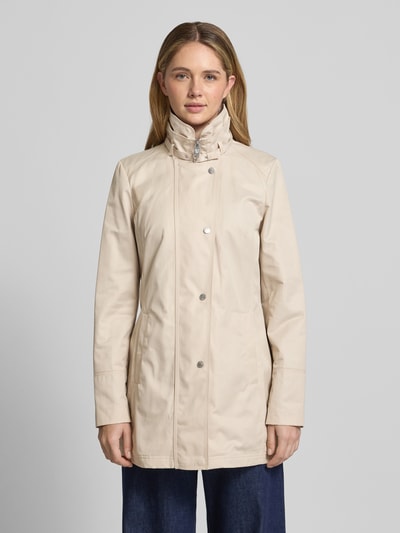 Frauenmodel trägt Trenchcoat mit Stehkragen und Eingrifftaschen von Fuchs Schmitt, beige, Baumwoll-Mix, tailliert, Ganzkörperansicht von vorne.