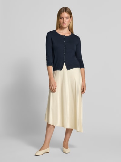 Modelka nosi kardigan Slim Fit z mieszanki wiskozy Model 'MAGLIA APERTA' od Liu Jo White, ciemnogranatowy, z listwą guzikową, Długość tyłu w rozmiarze S: 53 cm, Długość rękawów w rozmiarze S: 61 cm, krój slim fit, widok całej sylwetki z przodu.