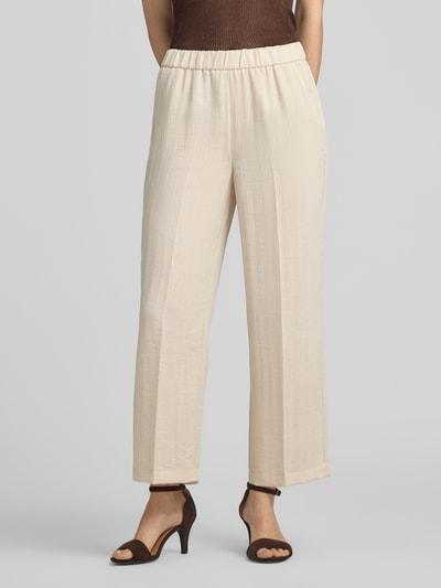 Vrouwenmodel draagt Wide Fit Hose aus Viskose-Mix mit Bügelfalten van comma, lichte beige mix van viscose, lyocell en linnen, wide fit, persplooien, elastische band, bandwijdte maat 36: 38 cm, binnenbeenlengte maat 36: 67 cm, voorkant detailopname van benen.