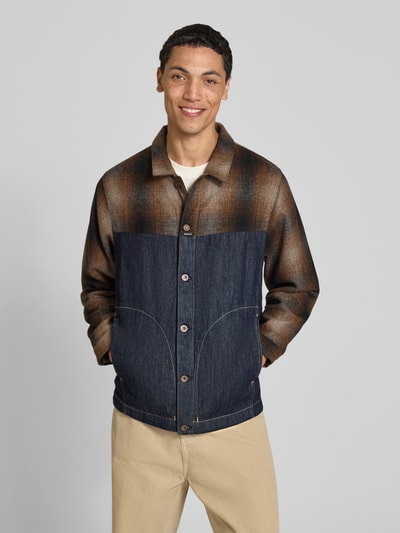 Männermodel trägt Slim Fit Hemdjacke aus reiner Baumwolle von Replay in Braun und Dunkelblau mit Umlegekragen, Ganzkörperansicht von vorne.