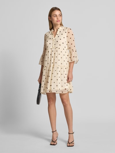 Frauenmodel trägt Tailliertes Minikleid mit V-Ausschnitt Modell 'SMILLA' von Vero Moda, Optik:Allover-Muster, Chiffon, Volants, Volantärmel, Minilänge, Ganzkörperansicht von vorne.