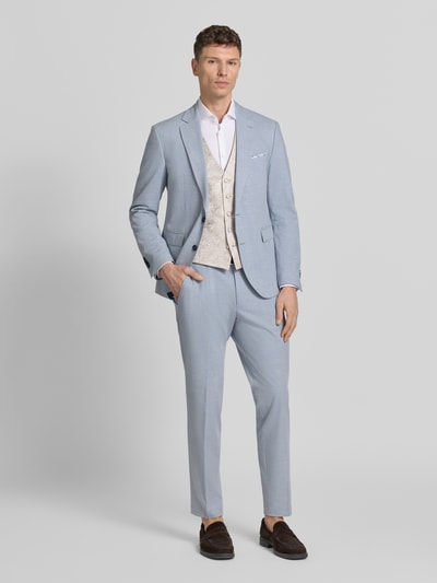 Männermodel trägt Weste mit V-Ausschnitt und Leistentaschen von Wilvorst in Beige, gerader Schnitt, kombiniert mit hellblauem Anzug, Ganzkörperansicht von vorne.