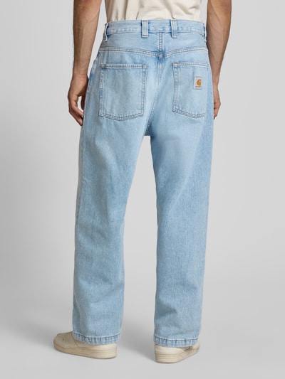 Männermodel trägt Wide Fit Jeans im 5-Pocket-Design Modell 'Brandon' von Carhartt Work In Progress, Reine Baumwolle, hellblaue Waschung, lockere Form, Bundweite bei Größe M 45 cm, Innenbeinlänge 72 cm, Ganzkörperansicht Rückansicht.
