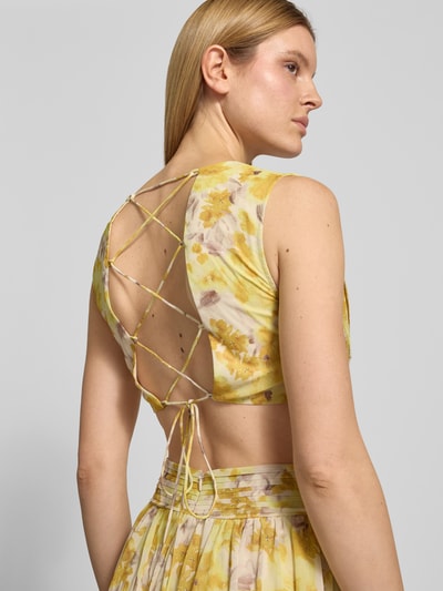 Frauenmodel trägt Regular Fit Maxikleid mit floralem Allover-Print von ADLYSH, Falten-Optik, V-Ausschnitt, Ärmelloses-Design, Rüschenbesatz, Cut-Outs, Schnürverschluss, Ganzkörperansicht Rückansicht.