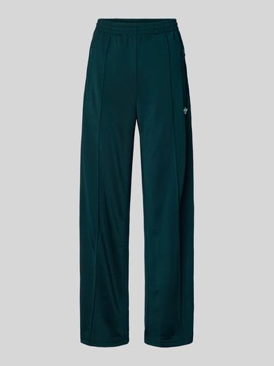Produktfoto, Sweatpants mit elastischem Bund von adidas Originals in Dunkelgrün mit Label-Stitching und Reißverschlusstaschen, lockerer Schnitt, Innenbeinlänge bei Größe S: 80 cm