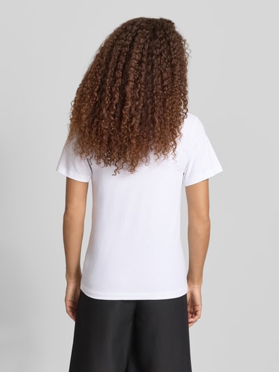 Modelka kobieca ma na sobie T-Shirt mit Logo-Print und Label-Patch od Karo Kauer, bawełna, krój straight fit, długość tyłu S: 62 cm, widok całej sylwetki z tyłu.
