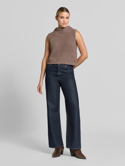 Frauenmodel trägt Regular Fit Top in Strick-Optik von monari in Braun mit Stehkragen und ärmellosem Design, Ganzkörperansicht von vorne, Rückenlänge bei Größe 36: 51 cm.