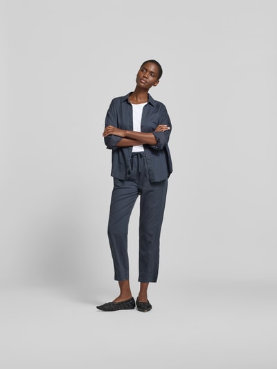 Frauenmodel trägt Stoffhose mit Lyocell-Anteil von Juvia in Dunkelblau, Baumwoll-Mix, verkürzte Passform, elastischer Bund, Ganzkörperansicht von vorne.