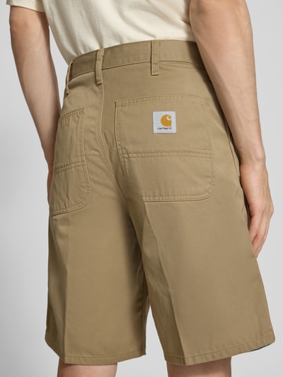 Männermodel trägt Bermudas mit Gesäßtaschen von Carhartt Work In Progress, Material-Mix mit Baumwoll-Anteil, Regular-Fit, Ganzkörperansicht Rückansicht.