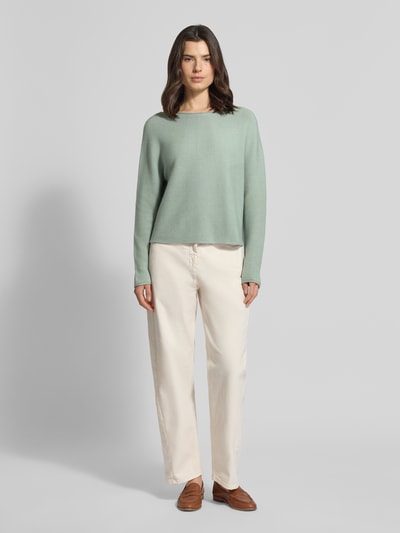 Frauenmodel trägt Strickpullover mit Rundhalsausschnitt von Comma aus Baumwoll-Mix, Regular-Fit, Rollsaum, hellgrün, Ganzkörperansicht von vorne.
