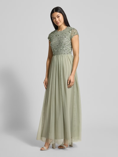 Kobiece model nosi Sukienka wieczorowa z cekinowym obszyciem od Lace & Beads, siateczka, taliowany krój, długość do ziemi, jednokolorowy, okrągły dekolt, halka, zapięcie na haftkę i wszyty zamek, długość tyłu 147 cm, szerokość klatki piersiowej 39 cm, długość rękawów 12 cm, jasny zielony, gładka tekstura spódnicy, zbliżenie na całe ciało z przodu.