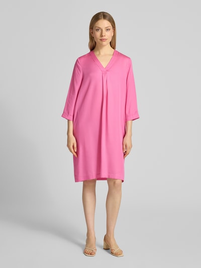Frauenmodel trägt knielanges Tunikakleid aus Lyocell von Lanius in Pink, gerader Schnitt, V-Ausschnitt, 3/4-Arm, Ganzkörperansicht von vorne.