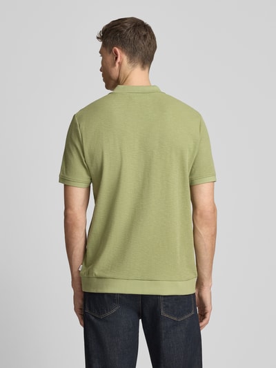 Männermodel trägt Comfort Fit Poloshirt mit V-Ausschnitt von Lindbergh in Grün, Reine Baumwolle, Strukturmuster, Label-Detail, Ganzkörperansicht Rückansicht. Rückenlänge bei Größe M: 68 cm.