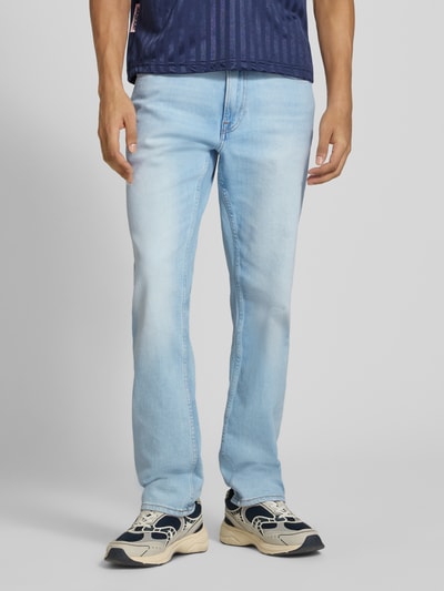 Männermodel trägt Slim Fit Jeans aus Baumwoll-Mix von Calvin Klein Jeans in hellblau, weiße und blaue Sneakers, Nahaufnahme Unterkörper, Herren Slim Fit Jeans von Calvin Klein Jeans.