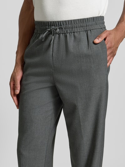 Männermodel trägt Relaxed Fit Hose mit elastischem Bund von Lindbergh in Grau, glatte Textur, mit Tunnelzug, Nahaufnahme Oberkörper.