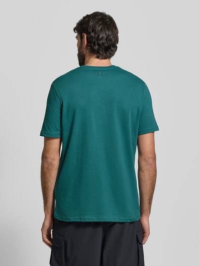 Männermodel trägt Regular Fit T-Shirt mit Logo-Print Modell 'Left' von Under Armour aus Baumwoll-Mix, Grün, Rückenansicht.