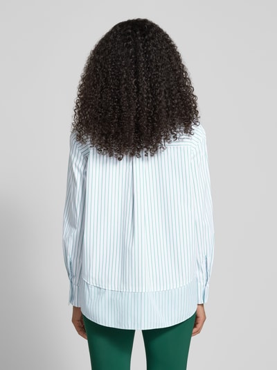 Frauenmodel trägt Regular Fit Bluse mit Brusttasche von Marc Cain aus reiner Baumwolle, weiß mit feinen Streifen, Rückenansicht, Ganzkörperansicht Rückansicht.