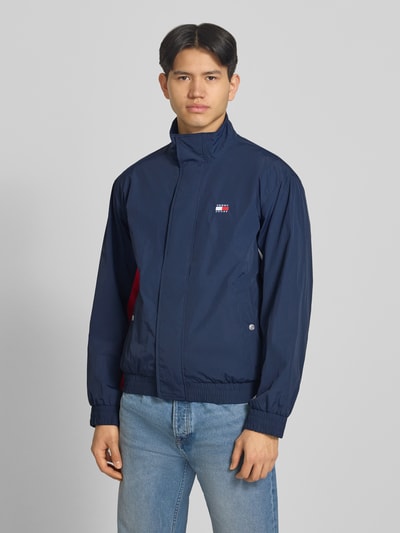 Mannenmodel draagt Regular Fit blouson met logo-stitching van Tommy Hilfiger in effen kleuren, satijn materiaalverwerking, Ganzkörperansicht von vorne.