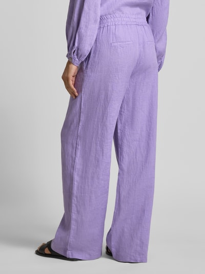Vrouwenmodel draagt Leinenhose mit elastischem Bund van Emily Van den Bergh in lila, puur linnen, wijde pijpen, paspelzakken, detailopname rugaanzicht.