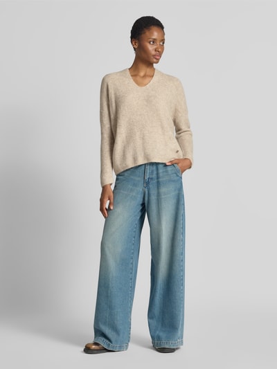 Vrouwenmodel draagt gebreide pullover uit mix van wol en alpaca met v-hals Model 'THORA' van MOS MOSH, regular fit, ruglengte maat S 82 cm, mouwlengte maat S 46 cm, dames, beige tinten, lichte textuur, vooraanzicht volledige lichaamsopname.
