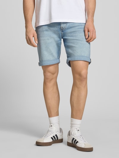 Männermodel trägt Slim Fit Jeansshorts aus Baumwoll-Mix Modell 'ABNER' von Calvin Klein Jeans in Denim-Optik, 5-Pocket-Design, Label-Patch, Knopf und verdeckter Reißverschluss, Hellblau, glatte Textur, Ganzkörperansicht von vorne.