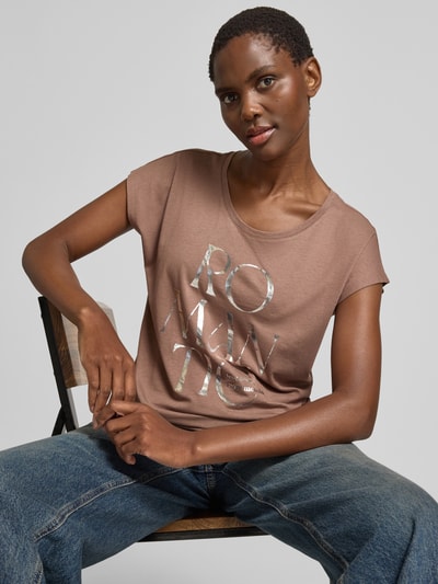 Frauenmodel trägt Regular Fit T-Shirt aus Viskose-Mix mit Statement-Print von Christian Berg Woman in Braun und Silber, Rundhalsausschnitt, Rückenlänge bei Größe S 56 cm, Nahaufnahme Oberkörper.