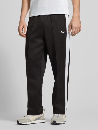 Männermodel trägt schwarze Straight Fit Sweatpants mit Logo-Stitching Modell 'Always On' von PUMA PERFORMANCE im Material-Mix mit Baumwoll-Anteil, Ziernähte, elastischer Bund, Eingrifftaschen mit Reißverschluss, Ganzkörperansicht von vorne.