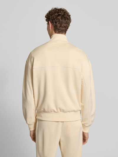 Męski model nosi Regular Fit Sweatjacke mit Baumwoll-Anteil od Lacoste, efekt: jednolity kolor, krój regular fit, zamek błyskawiczny, detal z logo, paski w kontrastowym kolorze, szew z wypustkami, stójka, długi rękaw, zakończenie rękawów i dołu prążkowane, wpuszczane kieszenie, dzianina dresowa, mieszanka materiałów z bawełną, całkowity widok z tyłu.