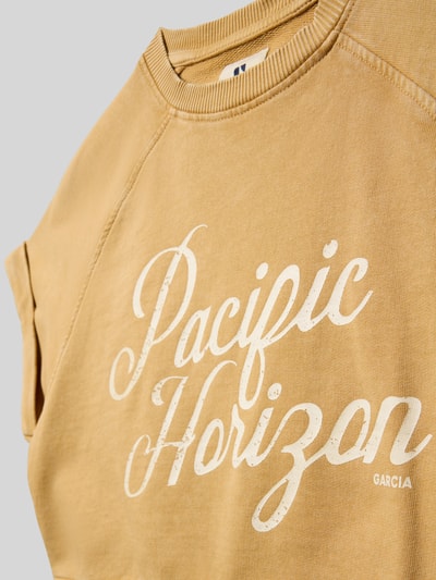 Mädchen trägt Cropped T-Shirt mit Statement-Print von Garcia aus Reine Baumwolle, Logo-Print, Rundhalsausschnitt, Nahaufnahme Oberkörper.