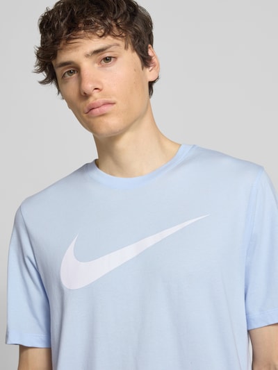 Männermodel trägt Herren T-Shirt mit Logo-Print Modell 'Swoosh' von Nike in Hellblau, Reine Baumwolle, Gerader-Schnitt, Nahaufnahme Oberkörper.