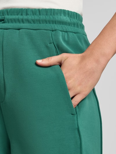 Frauenmodel trägt Relaxed Fit Shorts mit Tunnelzug von BOSS Orange, Optik: Unifarben, Passform: Relaxed-Fit, seitliche Eingrifftaschen vorne, Nahaufnahme Oberkörper.