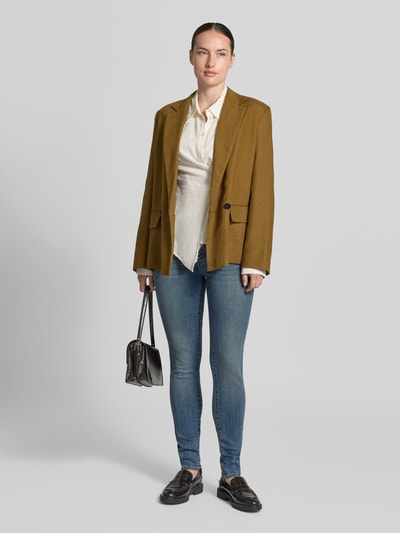 Frauenmodel trägt Skinny Fit Jeans mit Viskose-Anteil von Armani Exchange in klassischem Blau, 5-Pocket-Design, Ganzkörperansicht von vorne.