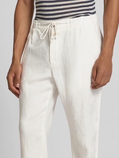 Männermodel trägt Tapered Fit Leinenhose von Closed aus reinem Leinen, mit Eingrifftaschen, Tunnelzug-Bund, Nahaufnahme Oberkörper.