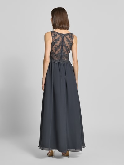 Frauenmodel trägt Abendkleid mit Ziersteinen und floralen Stickereien von LAONA in Dunkelgrau, doppellagiger Rock, Rückansicht Ganzkörperansicht.
