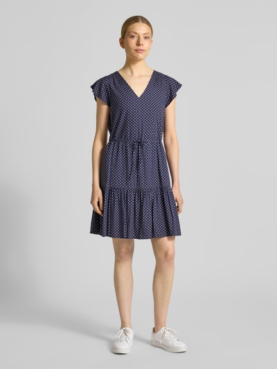 Vrouwenmodel draagt Minikleid aus reiner Viskose mit V-Ausschnitt van GAP, donkerblauw met witte stippen, getailleerde pasvorm, V-hals, tunnelkoord in taille, jurk met korte mouwen, borstwijdte maat S 85 cm, mouwlengte 11 cm, ganzlichaamsaanzicht van voren.