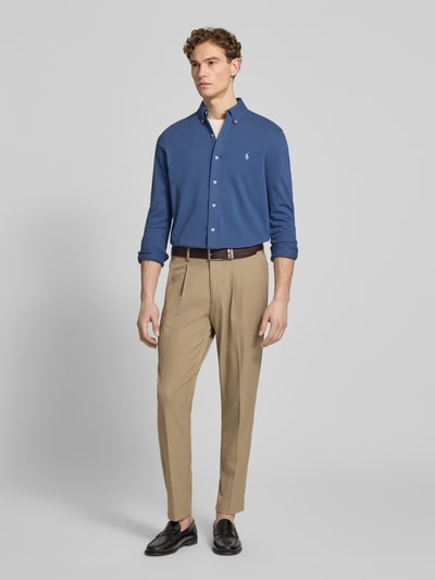 Männermodel trägt Regular Fit Freizeithemd aus reiner Baumwolle von Polo Ralph Lauren, unifarbenes Blau, langarm, Logo-Stitching, Ganzkörperansicht von vorne.
