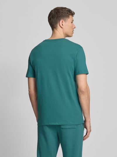 Männermodel trägt Herren T-Shirt mit Logo und Rundhalsausschnitt von GAP, grün, Reine Baumwolle, Regular-Fit, Rückenlänge 72 cm, Ganzkörperansicht Rückansicht.