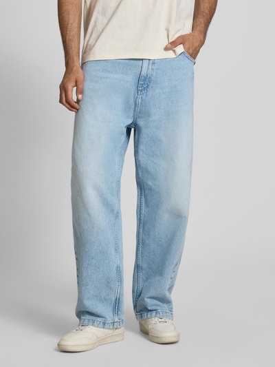 Männermodel trägt Wide Fit Jeans im 5-Pocket-Design Modell 'Brandon' von Carhartt Work In Progress aus Reine Baumwolle, hellblau, Ganzkörperansicht von vorne.
