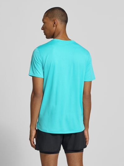 Männermodel trägt Regular Fit T-Shirt mit Logo-Print von ASICS in Türkis, glatte Struktur, kurze Ärmel, Rückansicht, Rückenlänge 71 cm.