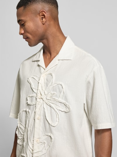 Männermodel trägt Regular Fit Freizeithemd aus reiner Baumwolle von JAKE*S STUDIO MEN, cremeweiß, florale Applikationen, Nahaufnahme Oberkörper.
