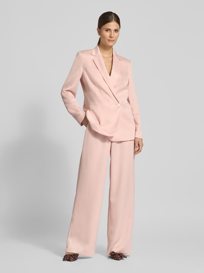 Frauenmodel trägt Wide Fit Stoffhose mit Gesäßtasche von Jake*s Collection in zartem Rosa mit Gürtelschlaufen, Ganzkörperansicht von vorne.