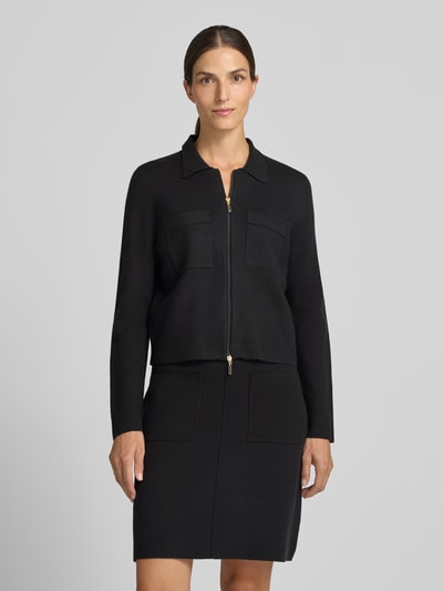 Kobiece modelka nosi Regular Fit kardigan rozpinany z czystej wiskozy od Christian Berg Woman, kolor czarny, wykładany kołnierz, zamek błyskawiczny dwustronny, nakładane kieszenie na piersi, luźny krój, Długość tyłu w rozmiarze S: 53 cm, Długość rękawów w rozmiarze S: 61 cm, widok całej sylwetki z przodu.