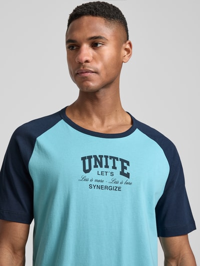 Męski model nosi Regular Fit T-Shirt aus reiner Baumwolle od s.Oliver RED LABEL, dwukolorowy, z nadrukiem, okrągły dekolt, krótkie rękawy, jersey, bawełna, zbliżenie na górną część ciała