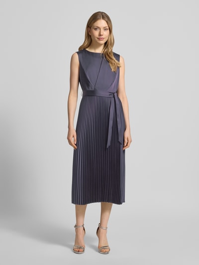 Frauenmodel trägt Midikleid mit Plisseefalten und Bindegürtel von Comma, Material-Mix mit Stretch-Anteil, A-Linie, Ganzkörperansicht von vorne.