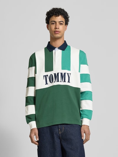 Männermodel trägt Relaxed Fit Poloshirt aus reiner Baumwolle von Tommy Jeans, Optik: unifarben, mehrfarbig, Ganzkörperansicht von vorne.