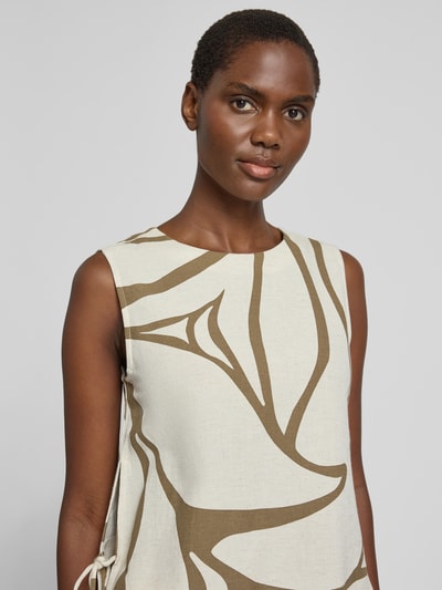 Frauenmodel trägt Blusentop aus Viskose-Mix mit seitlicher Schnürung von Vila, abstraktes Muster in Beige und Braun, Nahaufnahme Oberkörper. Regular Fit, Rundhalsausschnitt, Modell 'PRISILLA' mit Leinen-Anteil, Struktur leicht sichtbar.