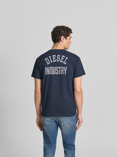 Männermodel trägt Regular Fit T-Shirt aus reiner Baumwolle von Diesel in Dunkelblau mit Label-Applikation, Rückenlänge 70 cm, Ganzkörperansicht Rückansicht.