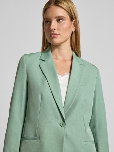 Frauenmodel trägt Blazer mit Reverskragen von Jake*s Collection in Mintgrün, lockerer Schnitt, Material-Mix, Nahaufnahme Oberkörper.